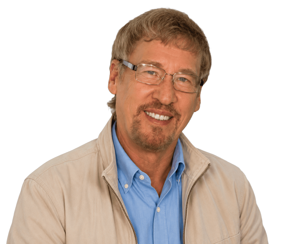 Remove the background from this portrait photo of Dr. Phil Tanner, keeping only the person with a completely transparent background. The man is wearing glasses, a blue shirt and beige jacket, smiling at the camera.